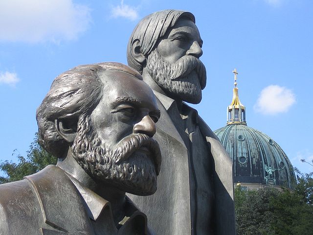 Berlin-Mitte. Das Marx-Engels-Denkmal auf dem Marx-Engels-Forum. Die beiden Köpfe – Foto: Manfred Brückels (GNU), < https://commons.wikimedia.org/wiki/File:MarxEngels_4a.jpg>